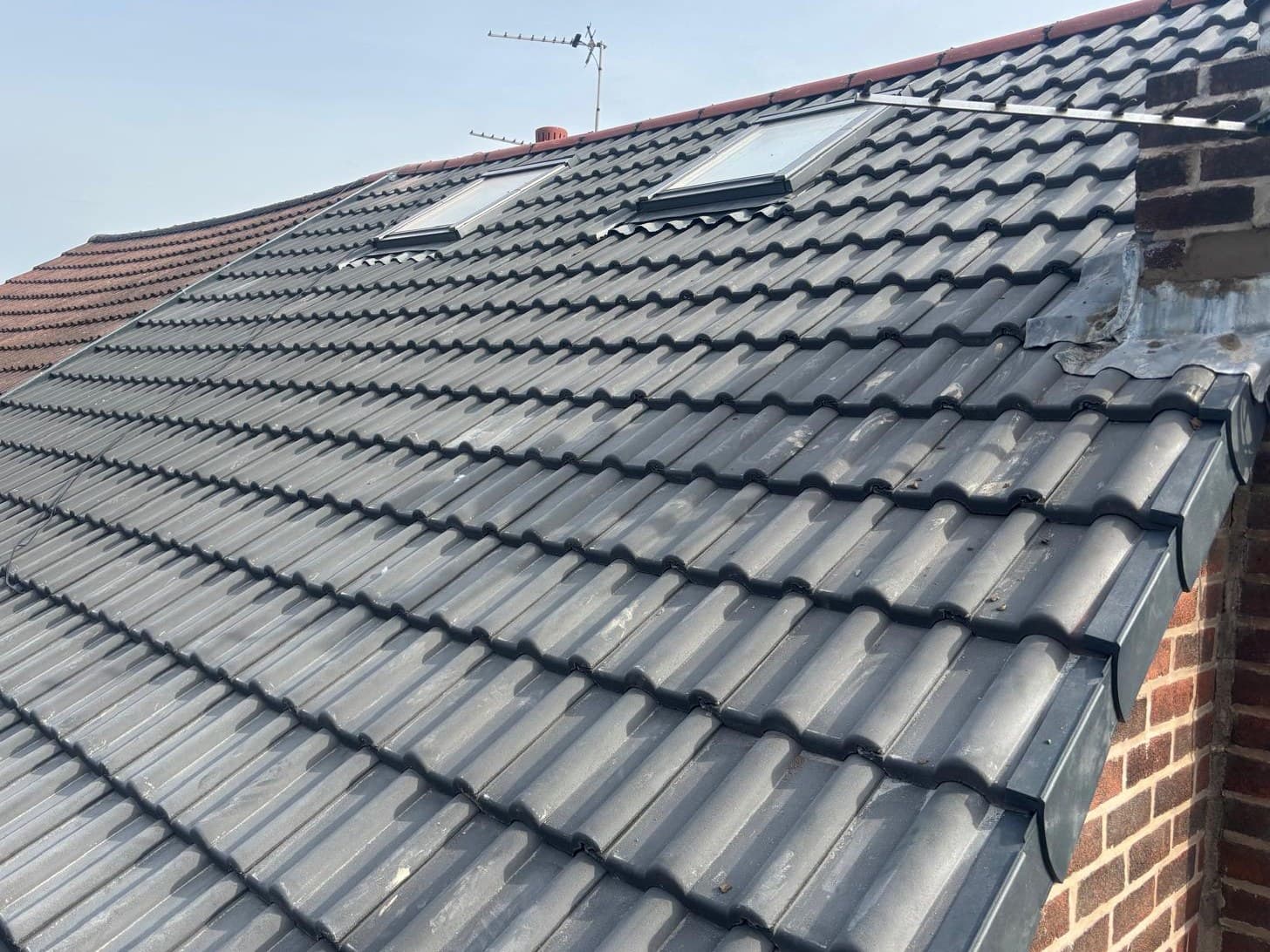 New grey tiled roof with Velux skylights and dry verge installation by Cooper Roofcraft domestic roofer Bury Manchester